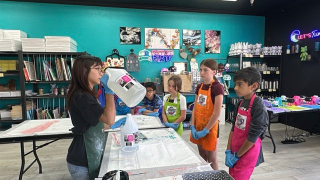 Studio instructor demonstrating fluid art technique to campers