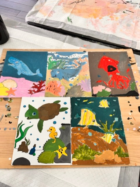 Collection of painted ocean art pieces made by campers