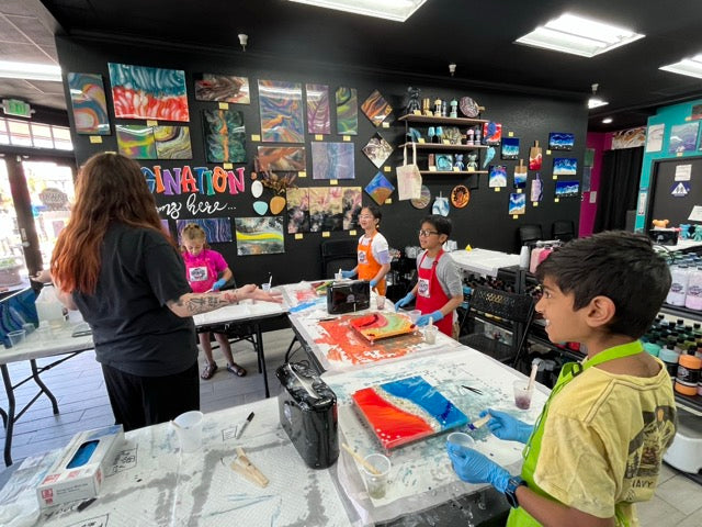 Campers working on resin projects during a camp week