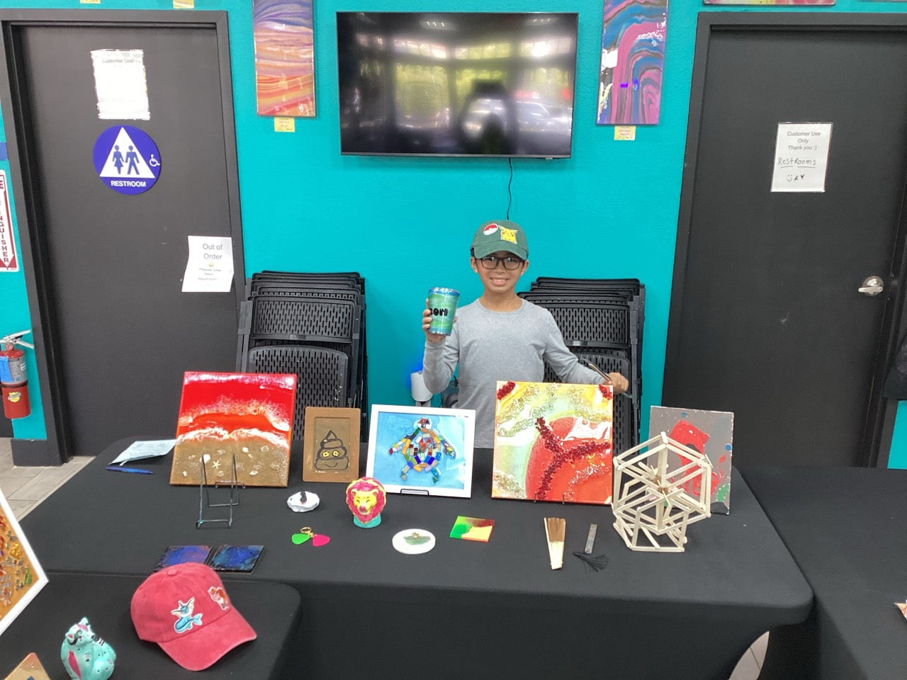 Camper holding his customized tumbler at the art showcase
